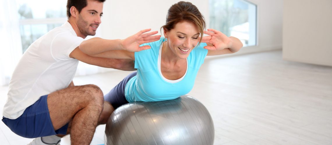 Woman doing pilates exercises with coach